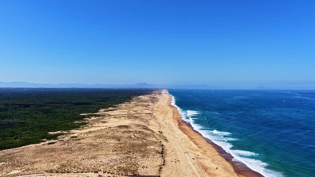 Aerial view of Plage des Oceanides with sandy dunes, forest, and waves along the Atlantic coast in Capbreton, Nouvelle-Aquitaine, France.