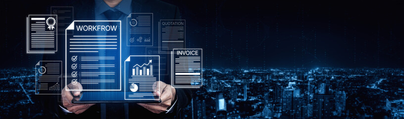 Obraz premium Modern Businessman Holding Digital Tablet with Workflow, Invoice, and Document Graphics Against City Skyline Background at Night. Bitwise.