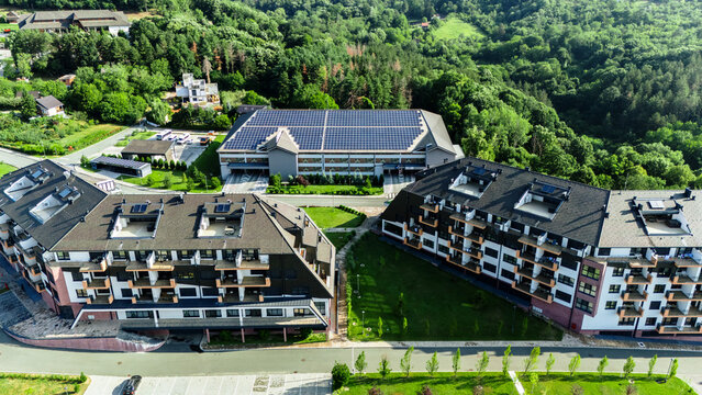 Aerial view of Movenpick Resort and Spa Fruske Terme with modern hotel buildings, solar panels, and lush forest surroundings, Vrdnik, Vojvodina, Serbia.