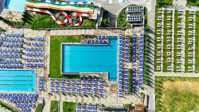 Aerial view of Movenpick Resort and Spa Fruske Terme featuring multiple swimming pools, colorful water slides, and organized rows of sun loungers in Vrdnik, Vojvodina, Serbia.