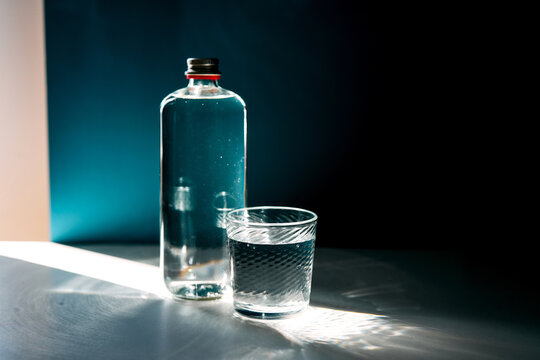 Water bottle and glass filled with clear liquid
