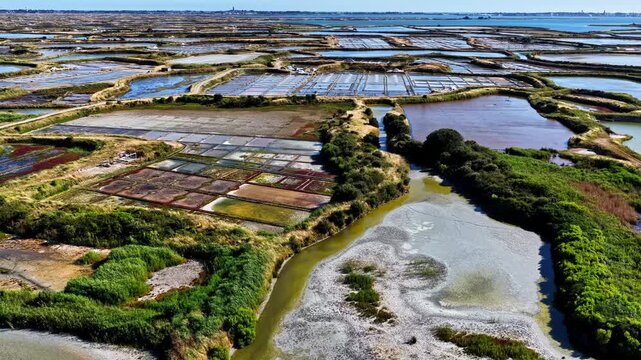 Aerial view of salt marshes with geometric pools and water channels in Capbreton, Nouvelle-Aquitaine, France.