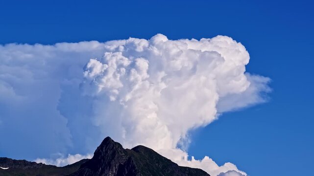 Aerial view of the massive cumulus cloud formation towering over the peak of Col d'Aubisque in Beost, Nouvelle-Aquitaine, France.