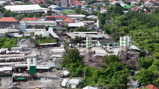 Aerial view of PT. Eco Park Engineering industrial facility featuring concrete silos, construction materials, and surrounding lush greenery in Denpasar Selatan, Bali, Indonesia.