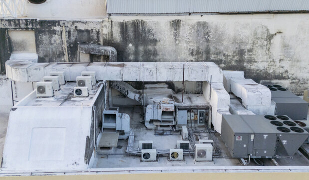 Aerial view of industrial air conditioning units, extensive metal ductwork, and solar panels installed on a flat rooftop in Merida, Yucatan, Mexico.
