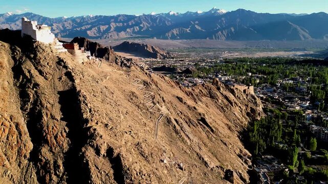 Aerial view of Leh Palace perched on a rocky mountain ridge overlooking the town of Leh, Ladakh, India.