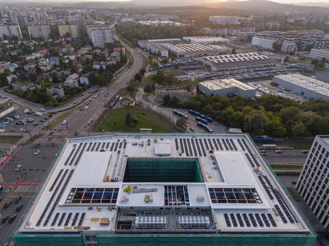 Aerial view of AI data center cooling system pipes and solar panels on a rooftop in an urban setting with surrounding roads and buildings in Krakow, Lesser Poland Voivode, Poland.