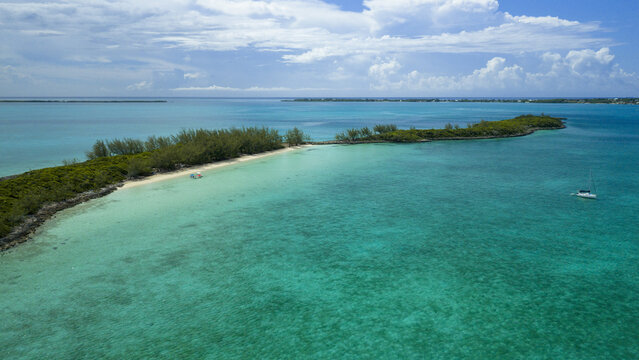 Aerial view of Spanish Wells island surrounded by turquoise waters, lush green vegetation, and a small boat in the clear sea, Spanish Wells, Spanish Wells, The Bahamas.