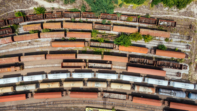 Aerial view of a train yard with various freight cars and tanker wagons parked on parallel tracks in Novi Sad, Vojvodina, Serbia.