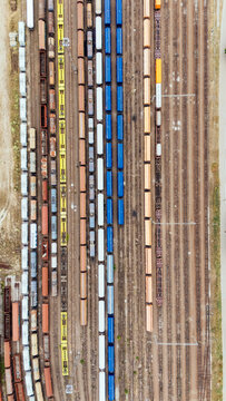 Aerial view of a railway yard with colorful freight trains and cargo cars parked on parallel tracks in Novi Sad, Vojvodina, Serbia.