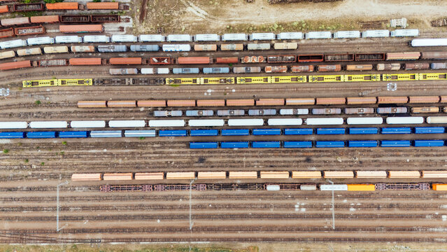Aerial view of a railway yard with numerous freight train cars in various colors and types, arranged on parallel tracks in Novi Sad, Vojvodina, Serbia.