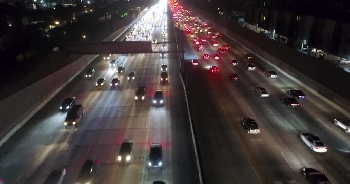 Aerial view of heavy traffic on a multi-lane highway at night with illuminated headlights and taillights in Los Angeles, California, United States.