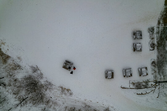 Aerial view of Dienersberger Weg in winter with snow-covered picnic tables and people standing in the snow in Oberstdorf, Bayern, Germany.
