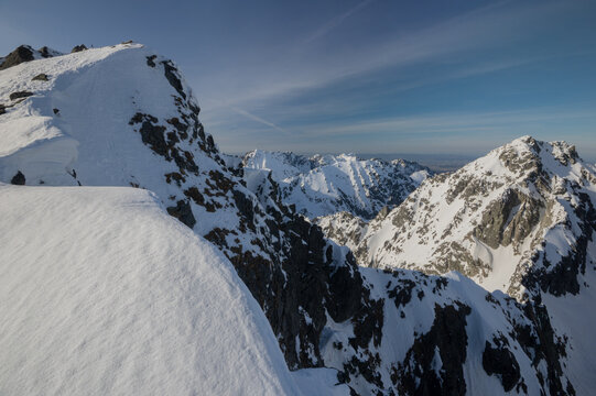 View of Cubrina peak seen from Koprovsky stit in the High Tatras national park with snow-covered mountain ridges and a clear blue sky in Vysoke Tatry, Presov Region, Slovakia.