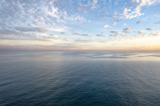 Kizkalesi, Turkey - 01 October 2025: Aerial view of the calm Mediterranean Sea at sunset with soft clouds in the sky near the coast of Kizkalesi.