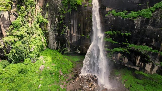 Aerial view of Jogini Falls cascading down a rocky cliff surrounded by lush green vegetation in Manali, Himachal Pradesh, India.