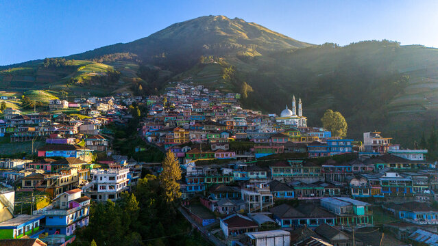 Kecamatan Kaliangkrik, Jawa Tengah, Indonesia - 15 July 2026: Aerial view of Nepal Van Java, a colorful village on Mount Sumbing slopes with terraced fields, vibrant houses, and a mosque.