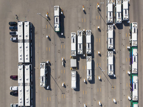 Aerial view of EBS RRReis Stalling Zwolle bus depot with rows of parked buses on asphalt, showing clear parking lanes and markings in Zwolle, Overijssel, Netherlands.
