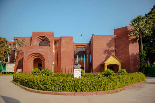Sonargaon, Dhaka Division, Bangladesh - 19 November 2025: View of the Bangladesh Folk Art and Crafts Museum, a red brick building with arched entrances and a central bust.