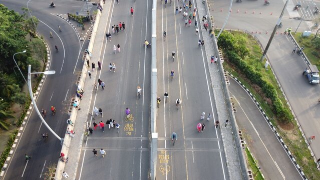 Bekasi Barat, Indonesia - 05 July 2020: Aerial view of people walking and cycling on a highway during a car-free day event in Bekasi Barat, West Java, Indonesia.