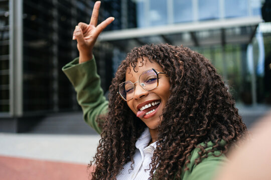 Playful African American Businesswoman Showing Victory Sign Outdoors