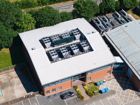 Aerial view of Six Degrees Data Centre featuring rooftop HVAC cooling ventilation units and brick architecture in Studley, England, United Kingdom.