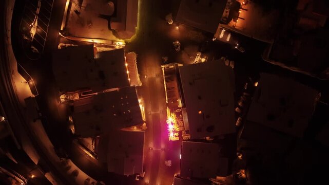 Aerial view of the illuminated Promenade street at night with surrounding buildings in Saanen, Bern, Switzerland.
