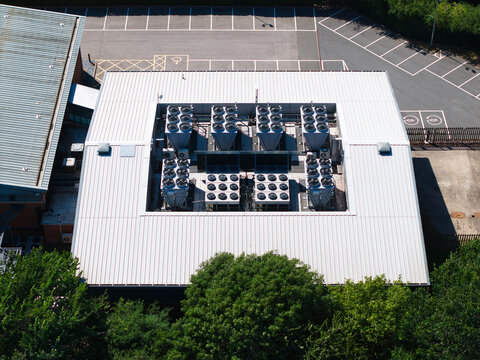 Aerial view of the Six Degrees Data Centre roof featuring industrial HVAC cooling units and AI automation infrastructure surrounded by parking and trees in Studley, England, United Kingdom.