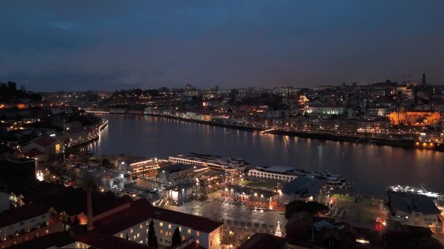 Aerial view of Porto city at night with illuminated buildings along the Douro River in Porto, Porto District, Portugal.