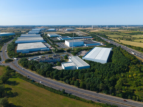 Aerial view of Daventry International Rail Freight Terminal featuring large industrial warehouses, distribution centers, and surrounding green landscape near Kilsby, England, United Kingdom.