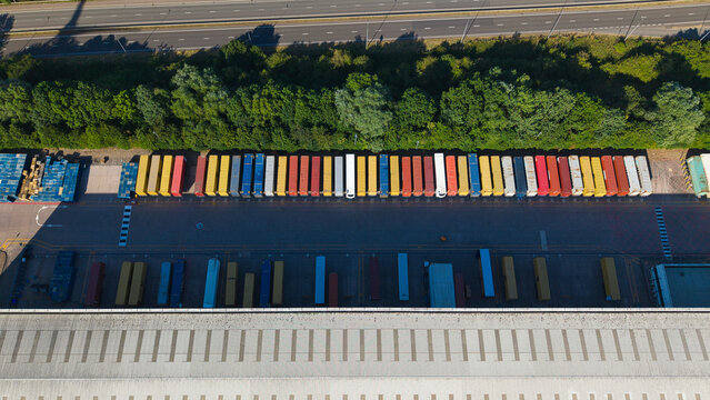 Aerial view of Daventry International Rail Freight Terminal showing rows of colorful shipping containers, warehouse facilities, and distribution areas in Kilsby, England, United Kingdom.