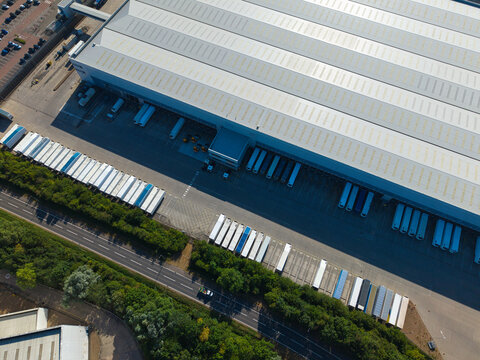 Aerial view of Daventry International Rail Freight Terminal featuring large warehouses, distribution centres, and numerous parked HGVs in Kilsby, England, United Kingdom.