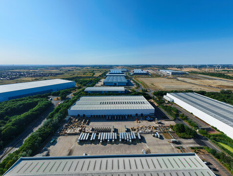 Aerial view of the Daventry International Rail Freight Terminal featuring large warehouses, distribution centres, and rows of parked HGVs in Kilsby, England, United Kingdom.