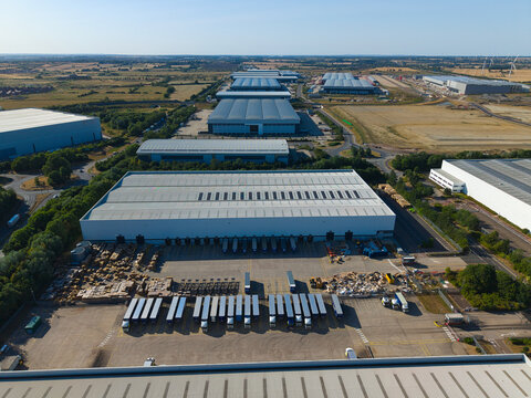 Aerial view of Daventry International Rail Freight Terminal featuring large warehouses, distribution centers, and rows of parked HGVs, Kilsby, England, United Kingdom.