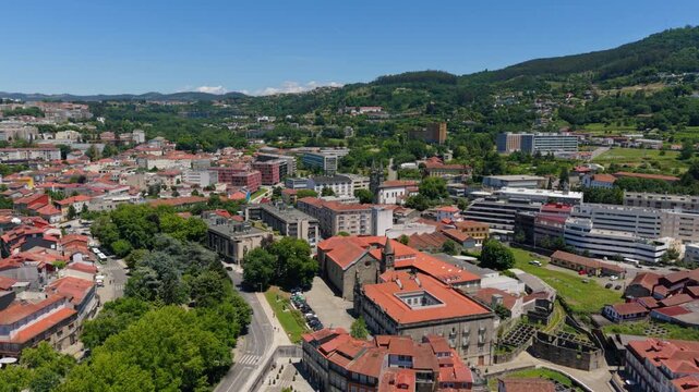 Aerial view of the historic Church of Saint Francis surrounded by traditional terracotta rooftops and lush green hills in the city of Guimaraes, Braga, Portugal.