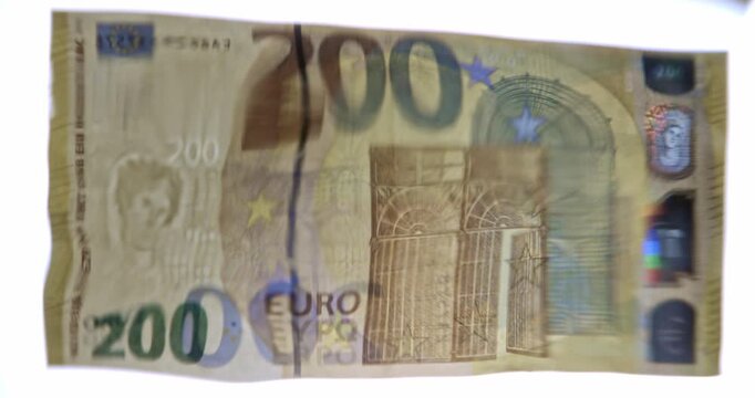 Volatility concept. Close-up studio video of a 200 Euro banknote viewed through a wavy water surface, creating a distorted and fluid appearance. 
