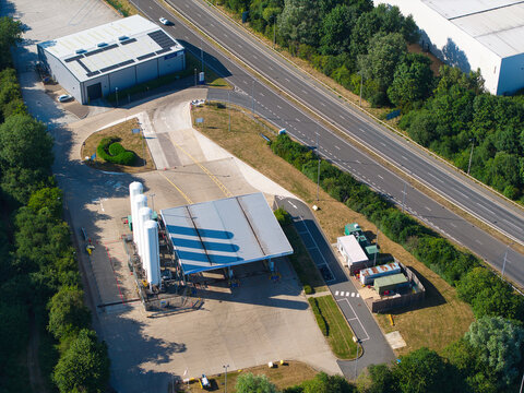 Aerial view of the Gasrec Bio-LNG refueling station at DIRFT with large white storage tanks, a canopy, and industrial buildings located near a highway in Kilsby, England, United Kingdom.