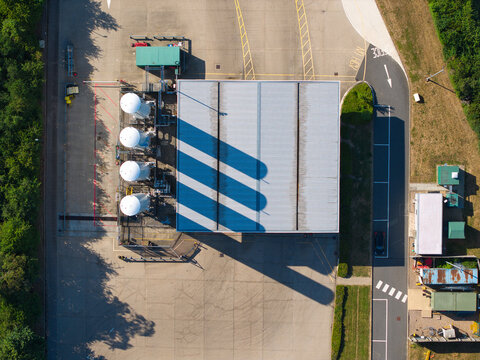 Aerial view of Gasrec Bio-LNG DIRFT facility with four large white cylindrical storage tanks and a building with a striped roof in Kilsby, England, United Kingdom.