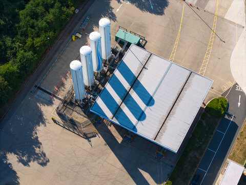 Aerial view of the Gasrec Bio-LNG refueling station at DIRFT featuring large white storage tanks and a canopy for heavy goods vehicles in Kilsby, England, United Kingdom.
