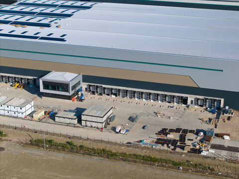 Aerial view of Daventry International Rail Freight Terminal featuring a large distribution warehouse with loading docks and modular offices in Kilsby, England, United Kingdom.