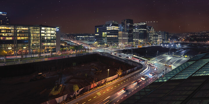 Oslo, Norway - 16 July 2026: View of the modern Barcode District skyline at night with illuminated buildings, light trails from traffic, and a construction site in the foreground.