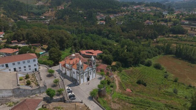 Aerial view of the Santuario de Nossa Senhora de Porto de Ave surrounded by lush greenery and historic buildings in Taide, Braga, Portugal.