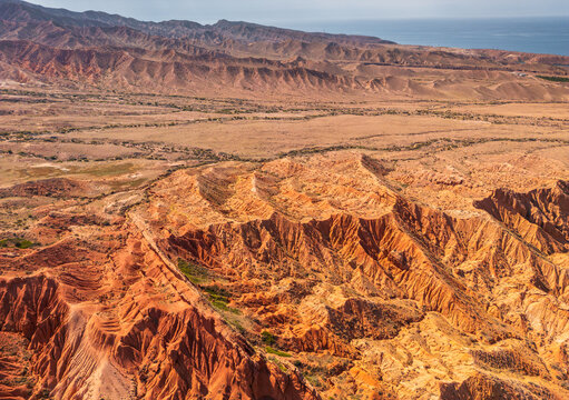 Aerial view of the dramatic red rock formations and rugged landscape of Skazka Canyon, also known as Fairy Tale Canyon, near Tosor, Issyk-Kul Region, Kyrgyzstan.