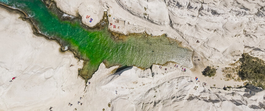 Aerial view of Sarakiniko Beach with its unique white volcanic rock formations and turquoise waters, Milos, Greece.