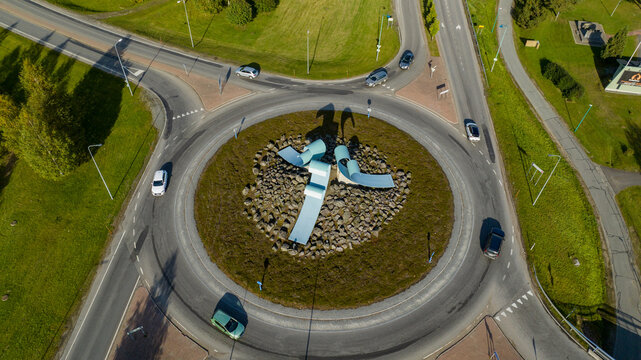Kuusamo, Finland - 10 September 2025: Aerial view of the roundabout sculpture in Kuusamo surrounded by roads, green grass, and passing cars.
