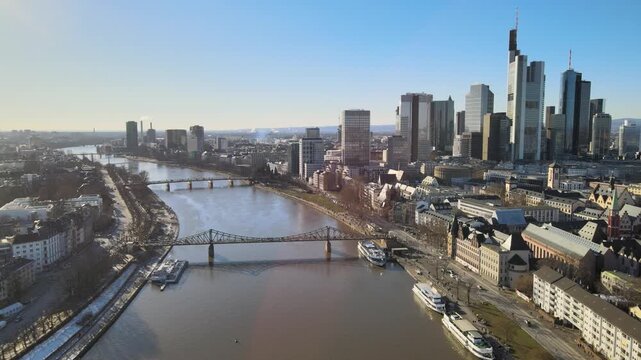 Aerial view of the Frankfurt am Main skyline with the Main river, historic bridges, and modern skyscrapers under a clear blue sky in Frankfurt am Main, Hessen, Germany.