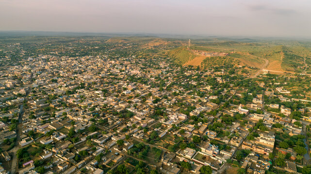 Aerial view of the town of Mithi with its dense residential layout, scattered greenery, and a prominent hill in the background, Mithi, Sindh, Pakistan.