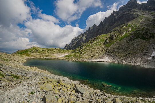 View of Zamrznute pleso surrounded by rugged rocky peaks and patches of snow in the High Tatras mountains in Tatranska Javorina, Presovsky kraj, Slovakia.