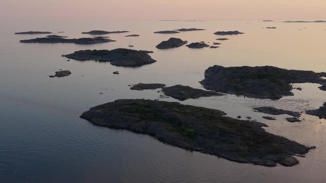 Aerial view of Billdal archipelago with rocky islands and calm sea during golden hour in Gothenburg, Vastra Gotaland County, Sweden.