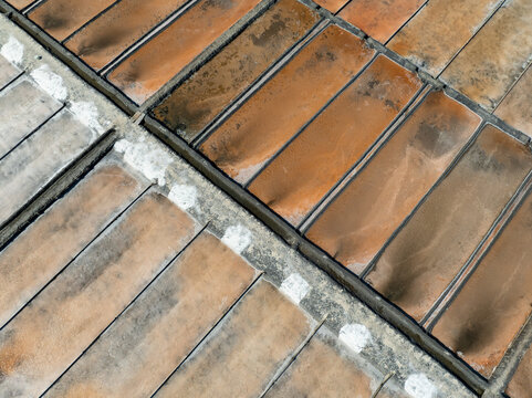 Aerial view of Salinas de Marinha da Noeirinha featuring rectangular salt pans with textured surfaces and concrete dividers in Vera Cruz, Aveiro, Portugal.